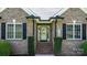 Charming brick home entrance with symmetrical windows, black shutters, and landscaped shrubbery at 1158 Waterford Dr, Hickory, NC 28602