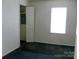 Simple bedroom with a window, neutral walls, and a glimpse into an adjoining room at 1230 Roberts St, China Grove, NC 28023