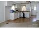 Bright kitchen with white appliances, white cabinets, and a seamless transition to an adjacent carpeted room at 1230 Roberts St, China Grove, NC 28023