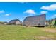 Spacious backyard featuring green grass, wooden fence, a wooden deck, and tall, thin trees at 126 Top Flite Dr, Statesville, NC 28677