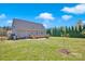 Large backyard featuring green grass, a wooden deck, a fire pit, and tall, thin trees at 126 Top Flite Dr, Statesville, NC 28677