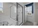 Bright, updated bathroom features an all-glass shower and window at 12710 Es Draper Dr, Huntersville, NC 28078