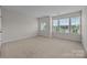 Well-lit bedroom featuring neutral carpet, light walls, and large windows at 12710 Es Draper Dr, Huntersville, NC 28078