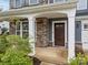 Inviting front entrance with stone accents, white pillars, and a dark wood front door at 12710 Es Draper Dr, Huntersville, NC 28078