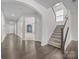 Bright and open foyer with hardwood floors, a staircase, and views to the living spaces at 12710 Es Draper Dr, Huntersville, NC 28078