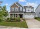 Charming two-story home with stone accents, a well-manicured lawn, and a two-car garage at 12710 Es Draper Dr, Huntersville, NC 28078