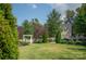 Charming front yard with a white picket fence, green lawn, and mature trees and shrubs at 12710 Es Draper Dr, Huntersville, NC 28078