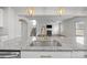 Open concept kitchen with granite countertop island, stainless steel sink and adjacent living room at 12710 Es Draper Dr, Huntersville, NC 28078