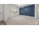 Bright living room with large windows, a modern light fixture, and a striking accent wall at 12710 Es Draper Dr, Huntersville, NC 28078