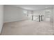 Upstairs loft area with neutral carpet, window and access to rooms at 12710 Es Draper Dr, Huntersville, NC 28078