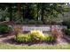 Community sign with stone background featuring landscaping and bright flowering plants at 12710 Es Draper Dr, Huntersville, NC 28078