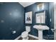 Stylish powder room with unique wallpaper, pedestal sink, and modern fixtures at 12710 Es Draper Dr, Huntersville, NC 28078