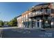 Street view of commercial property featuring second-story balconies and brick facade at 12710 Es Draper Dr, Huntersville, NC 28078