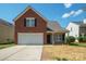 Charming two-story brick home with a two-car garage and well-maintained front yard at 1409 Rheo Nw Ct, Concord, NC 28027