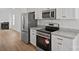 Modern kitchen features stainless steel appliances, granite countertops, and white cabinets at 1409 Rheo Nw Ct, Concord, NC 28027