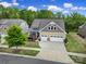 Aerial view of a well-maintained home with a two-car garage, lush landscaping, and a spacious driveway at 1497 Tranquility Blvd # 417, Lancaster, SC 29720