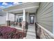 Cozy front porch with seating area, stone pillars, and black railings, creating a welcoming entrance at 1497 Tranquility Blvd # 417, Lancaster, SC 29720