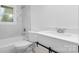 A white tiled bathroom featuring a shower-tub combo, white vanity, and sliding barn door storage at 1500 19Th Avenue Ne Pl, Hickory, NC 28601