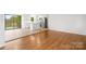 Bright living room with hardwood floors transitioning into a kitchen with light-colored wood floors at 1500 19Th Avenue Ne Pl, Hickory, NC 28601