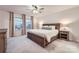 Calm bedroom with a wooden bed frame, coordinated bedside lamps, and view from bright windows at 15116 Caspian Way, Charlotte, NC 28278