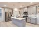 Modern kitchen with gray cabinets, stainless steel appliances, and a central island with pendant lighting at 15116 Caspian Way, Charlotte, NC 28278