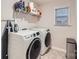 Efficient laundry room equipped with modern washer, dryer, and convenient shelving for storage at 15116 Caspian Way, Charlotte, NC 28278