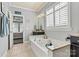 Bright bathroom featuring a soaking tub, granite counters, and a window with plantation shutters at 152 Blossom Ridge Dr, Mooresville, NC 28117