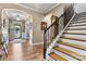 Inviting home entrance featuring hardwood floors, staircase, and chandelier, with convenient access to multiple rooms at 152 Blossom Ridge Dr, Mooresville, NC 28117