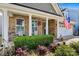 Charming brick home featuring a welcoming front porch with white columns and beautiful landscaping at 152 Blossom Ridge Dr, Mooresville, NC 28117