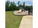 Community playground area with slide and climbing structure, surrounded by lush greenery and a secure fence at 152 Blossom Ridge Dr, Mooresville, NC 28117