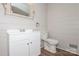Bathroom with a white vanity, toilet, shiplap walls, decorative mirror, and vinyl floors at 1637 Buckingham Ave, Gastonia, NC 28054