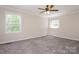 Spacious bedroom with two windows, ceiling fan, and plush neutral carpeting at 1637 Buckingham Ave, Gastonia, NC 28054