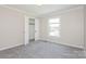 Bright bedroom featuring neutral walls, closet, carpet, and natural light from a window at 1637 Buckingham Ave, Gastonia, NC 28054