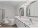 Bright bathroom featuring dual vanities, framed mirrors, soaking tub, and separate shower, offering luxury at 18700 Nautical Dr # 203, Cornelius, NC 28031