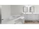 Bright white bathroom featuring a soaking tub, dual sinks with a neutral tile floor, and bright light fixtures at 18700 Nautical Dr # 203, Cornelius, NC 28031