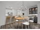 Modern kitchen featuring stainless steel appliances, granite countertops, and a stylish chandelier over the dining area at 18700 Nautical Dr # 203, Cornelius, NC 28031