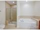 Bathroom with large soaking tub and a glass-enclosed shower at 1910 Mezzo Ct, Matthews, NC 28105
