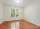 Bright bedroom with hardwood floors, a large window with blinds, and neutral wall color at 1910 Mezzo Ct, Matthews, NC 28105