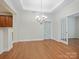 Formal dining room with elegant chandelier, hardwood flooring, and access to kitchen and den at 1910 Mezzo Ct, Matthews, NC 28105