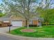Traditional home featuring brick and stone exterior, large driveway, mature trees and well-kept lawn at 1910 Mezzo Ct, Matthews, NC 28105