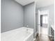 A relaxing bathroom featuring a tub, shower, and gray walls leading into a bedroom, offering a spa-like atmosphere at 2059 Lennox Square Rd, Charlotte, NC 28210