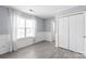 A naturally lit bedroom with large windows, complemented by elegant wall paneling and a double closet for ample storage at 2059 Lennox Square Rd, Charlotte, NC 28210