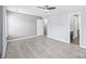 A bright, open bedroom with light gray walls, wood-look floors, and a ceiling fan, offering a clean and modern aesthetic at 2059 Lennox Square Rd, Charlotte, NC 28210