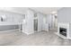 Open-concept living room with modern fireplace, updated lighting, and grey plank flooring at 2059 Lennox Square Rd, Charlotte, NC 28210