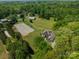 Aerial view of the property showcasing the house, barn, riding ring, and lush surrounding landscape at 228 Red Dog Dr, Mooresville, NC 28115