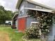 Exterior of barn with climbing pink roses and red doors with white trim accents at 228 Red Dog Dr, Mooresville, NC 28115