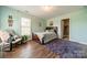Comfortable bedroom with wood floors, accent chair, and a walk-in closet at 228 Red Dog Dr, Mooresville, NC 28115
