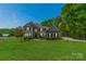 Beautiful two story home with a lush green lawn, mature trees, and architectural details at 228 Red Dog Dr, Mooresville, NC 28115