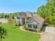 Spacious two-story home with a manicured lawn, and mature trees, surrounded by lush greenery at 228 Red Dog Dr, Mooresville, NC 28115