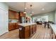 Bright kitchen with hardwood floors, wooden cabinets, a kitchen island, and stainless steel appliances at 228 Red Dog Dr, Mooresville, NC 28115